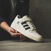 یک فرد درحال نگه داشتن یک کفش آدیداس